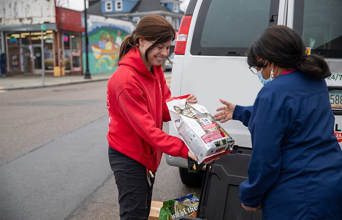 ARL staff member handing someone a bag of pet food